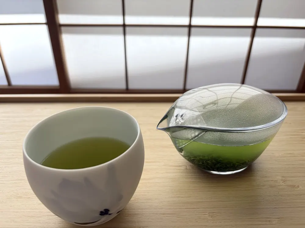 障子の前で、ガラスの片口と湯呑みに淹れた宇治茶「ゆと葉」の煎茶